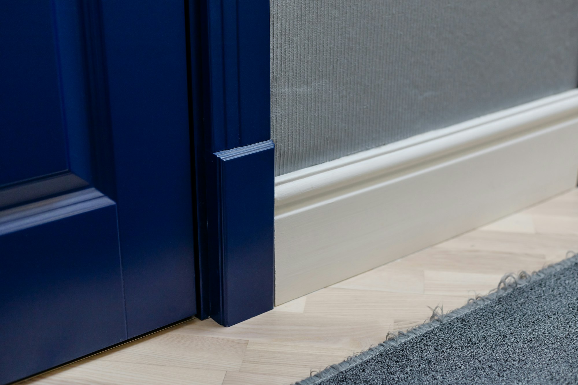 Blue wooden door and adjoining high classic floor plinth. Interior decor elements